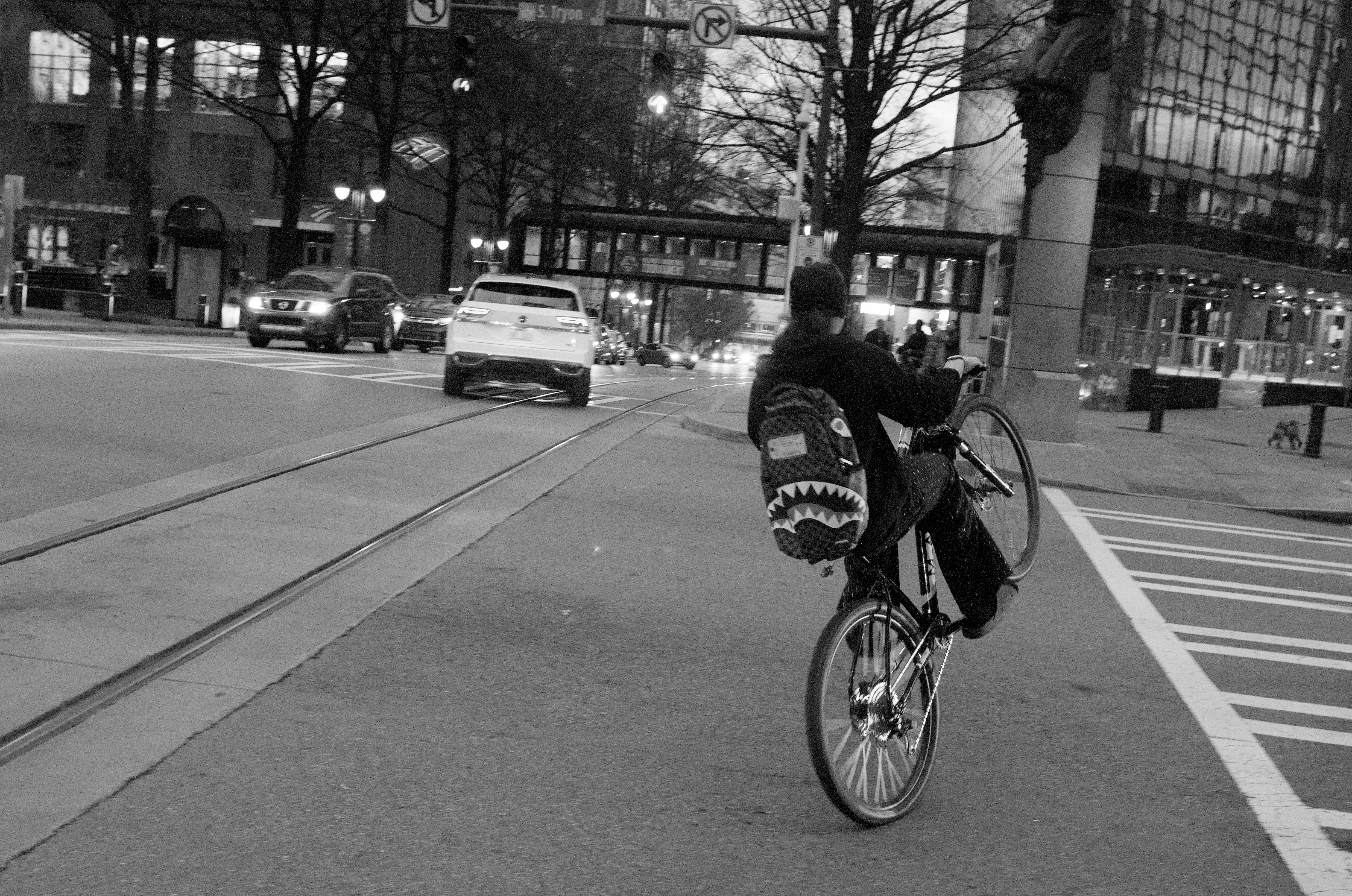 A person on a bike facing away from the camera, doing a wheelie