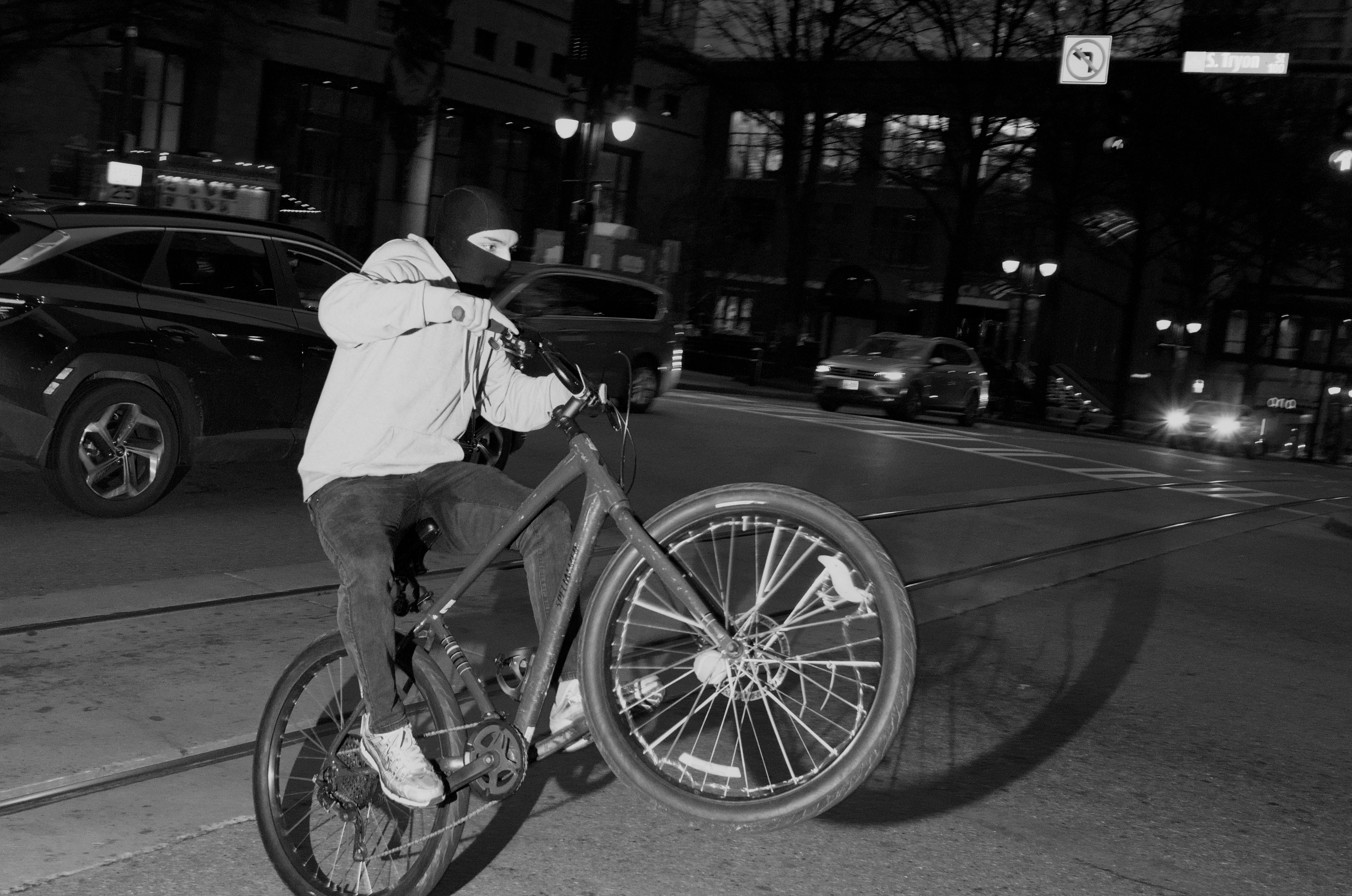 A person doing a wheelie on a bike facing to the right