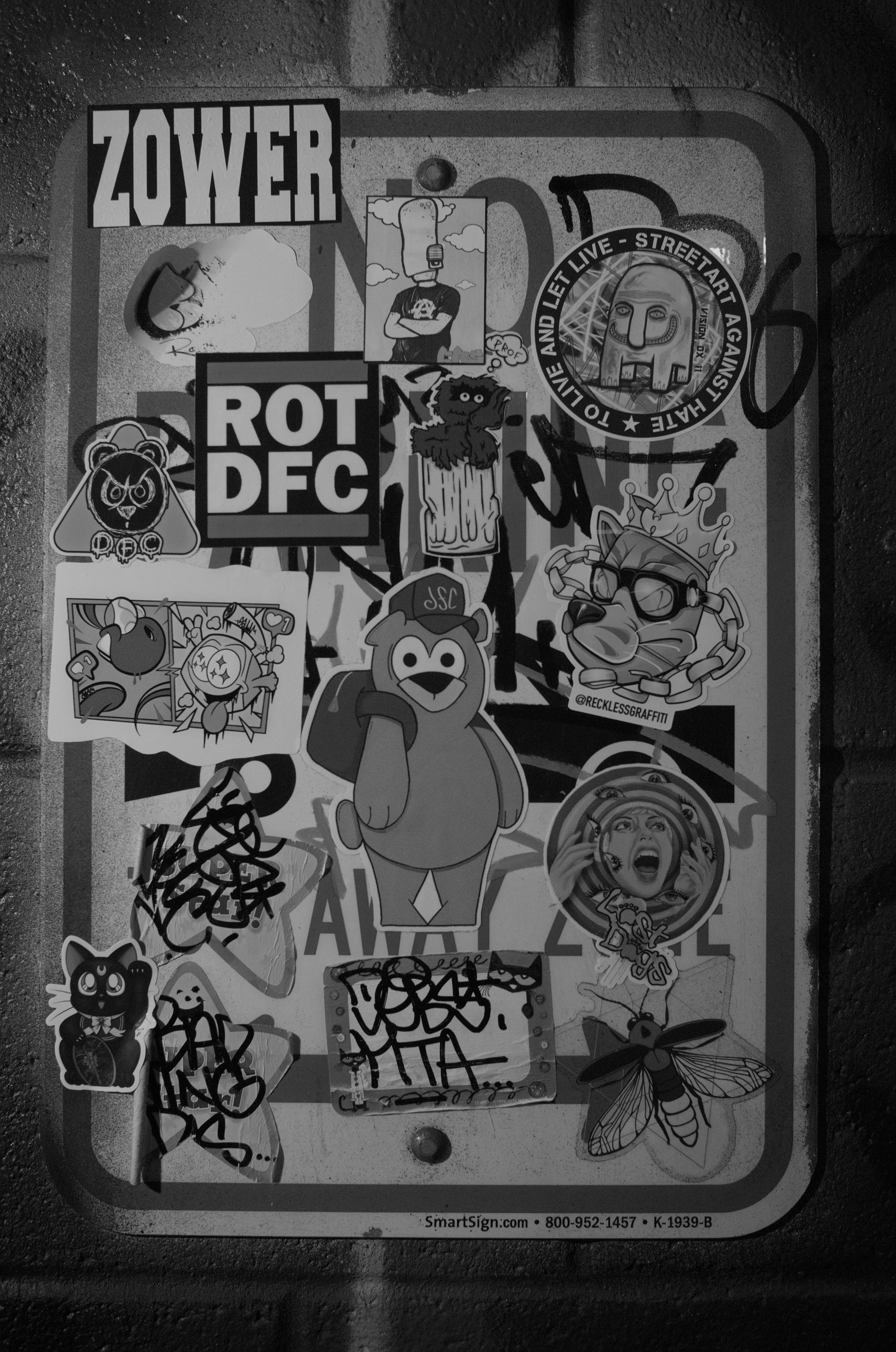 A street sign covered in stickers and graffiti